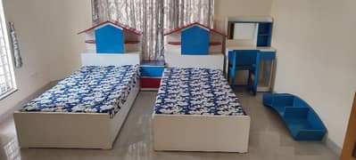 kids pair of beds with study table and book rack.