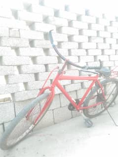Red colored bicycle having gears and cycle is in new condition