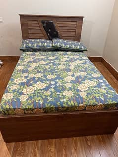 Wooden bed with mattress .