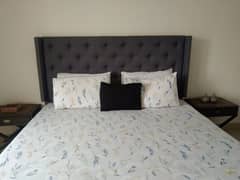 tufted double bed with two side tables