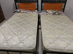 2 Single iron beds with spring mattresses