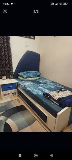 blue  single bed with mattresses side and table and dressing table