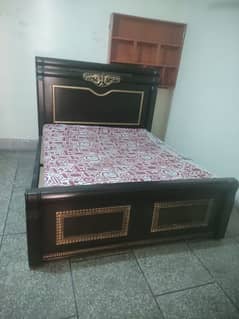 wooden bed with two side tables and a dressing table