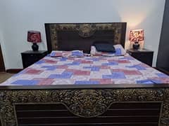 Double bed with mattress, side table and dressing table.