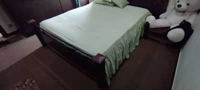 Wooden double bed with spring mattress and wall mirror