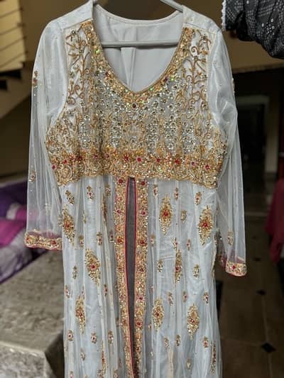 white Bridal Dess With Golden and Red work on it.