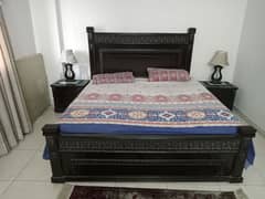 unique hand made heavy wood bed with two side tables and on dressing