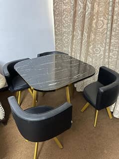 Table and 4 chairs with gold, black marble effect and black leather