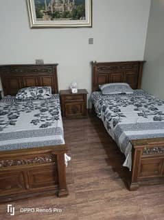 two single hand made beds with two sidetables  and metresswith metress