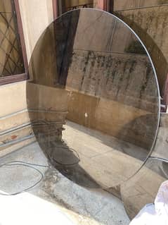 Tinted round glass table top 0.5 inches thick, 5 feet in diameter.