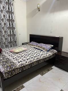 wooden double bed with side tables with mattress