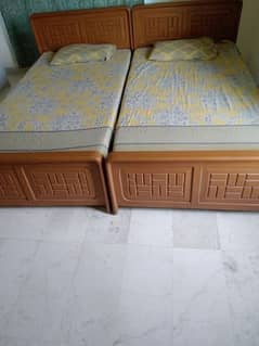 Two wooden single beds