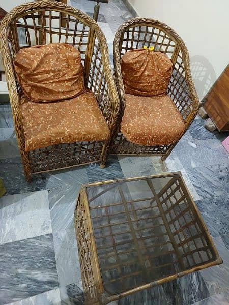 2 cane chairs with cushions/ cane table 3