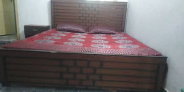 wooden bed with side tables and mattress