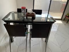 glass dining table with 4 wood chairs