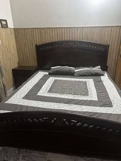 A very good condition wooden bed with two side tables and dressing