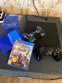 PlayStation 4 slim with 2 controllers and 2 games