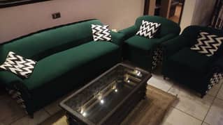 green sofa set with cushions with center table and side tables