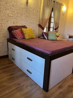 single bed with mattress and a storage box