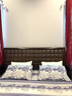 Wooden bed set with tufted headboard.