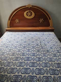 wooden bed with mattress and dressing table