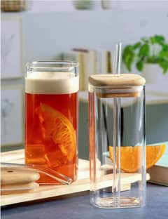 Glass tumbler with wooden lid and straw