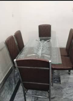 A glass dining table with 6 chairs