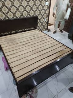 solid wooden bed with a master molty mattress and single side table.