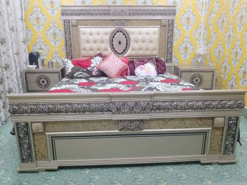 A bed with two sides tables and dressing table 0