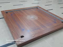 Carrom board with polished wooden surface.