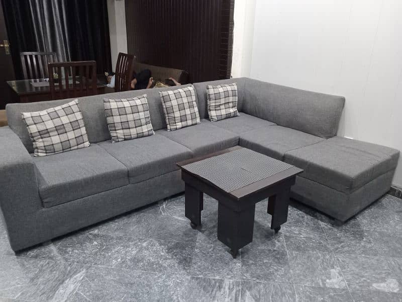 L shape sofa 7 seater. Grey colour with cushions and a table 2