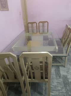 dinning table with wooden frame and glass top with 6 dinning chairs