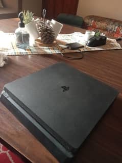 PS4 slim, with 2 controllers, 2 games, and one charging dock.