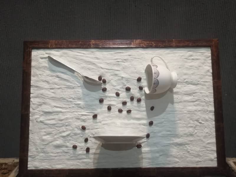 wall frame of a falling coffee cup sclupture 0