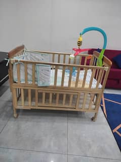 Wooden baby cot with bedding and swing toy