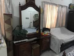 A normal dressing table fully wooden with sitting stool