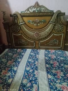 a wooden bed with a shockcage and a dressing table