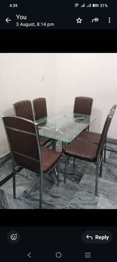 A glass dining table with 6 chairs