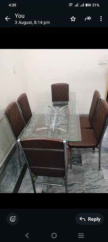 A glass dining table with 6 chairs 2