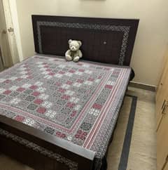 A double bed with matress and side tables