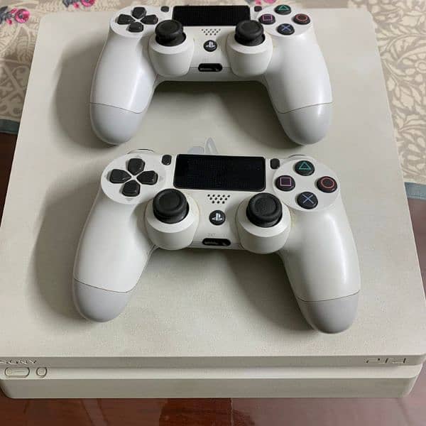 PS4 Slim White Edition with 2 controllers and 7 games. 0