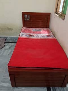 wooden single bed along with mattress