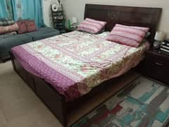 Dark brown sheesham wood bed with two side tables.