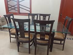 Wooden table (6 chairs) with glass top.