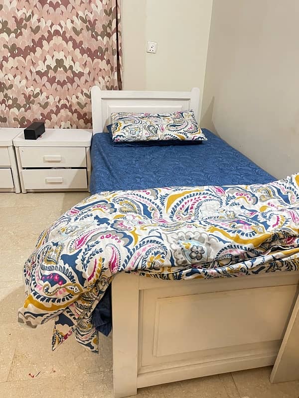 two wooden single beds with side table 2