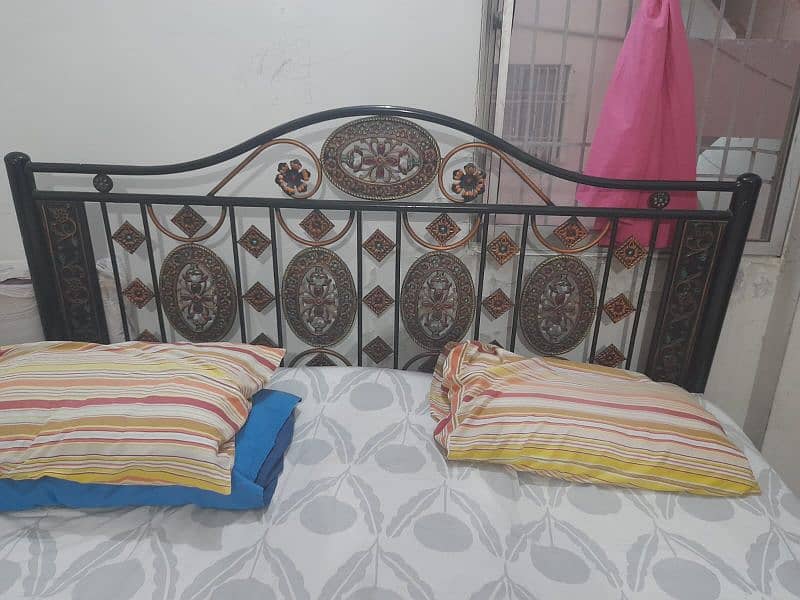 iron bed and single wooden bed 0