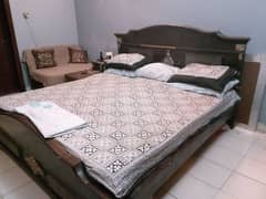 wooden kig size bed along with side table and mattress