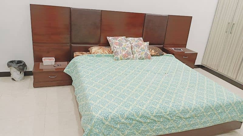 king size heavy down bed with two side tables and dressing 0