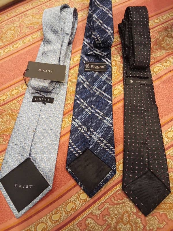 A bunch of men ties of different brands  Exist- Uniworth- Figure peeru 3