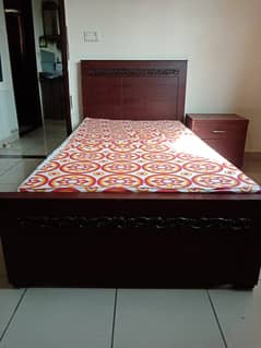 Single bed with mattress and one side table